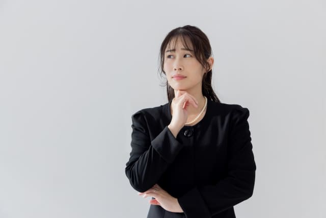 悩む喪服の女性