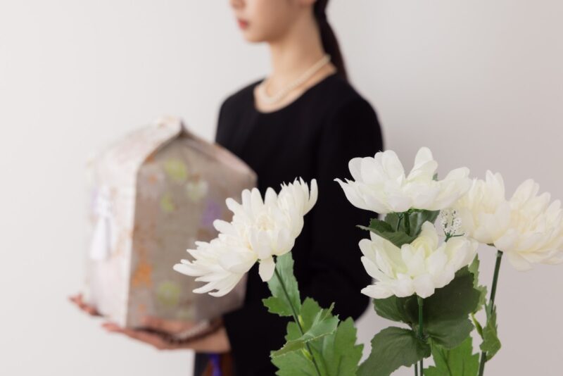 骨つぼを持つ女性